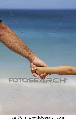 Father and child holding hands at beach View Large Photo Image Stock Photo - Father and child holding hands at beach. Fotosearch