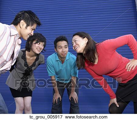 Stock Photo - Group of friends in huddle next to building. Fotosearch