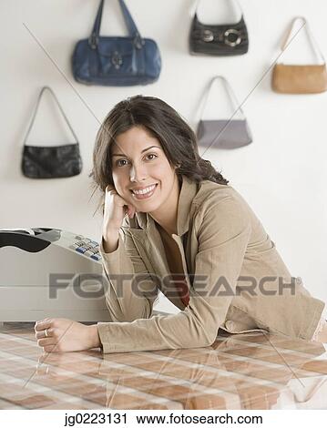 Hispanic businesswoman behind counter at boutique View Large Photo Image Stock Image - Hispanic businesswoman behind counter at boutique. Fotosearch