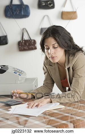 Hispanic businesswoman paying bills at boutique View Large Photo Image Stock Image - Hispanic businesswoman paying bills at boutique. Fotosearch