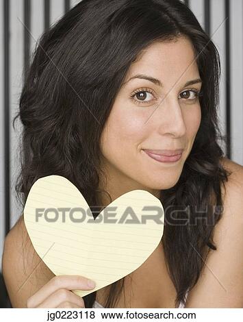 Hispanic woman holding cut out paper heart View Large Photo Image Stock Photo - Hispanic woman holding cut out paper heart. Fotosearch