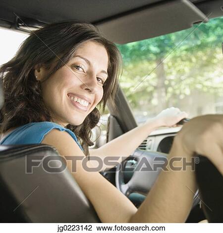 Stock Image - Hispanic woman in driver's seat of car. Fotosearch