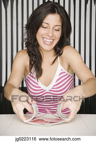 Stock Photograph - Hispanic woman shuffling playing cards. Fotosearch