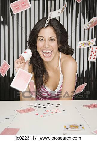 Stock Photo - Hispanic woman throwing playing cards. Fotosearch