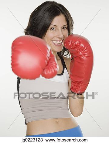 Stock Image - Hispanic woman wearing boxing gloves. Fotosearch