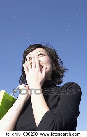 Low angle view of Asian woman laughing View Large Photo Image Stock Image - Low angle view of Asian woman laughing. Fotosearch