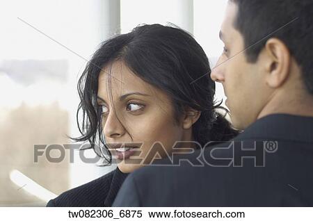 Stock Photography - Middle Eastern businesswoman looking over man's shoulder. Fotosearch