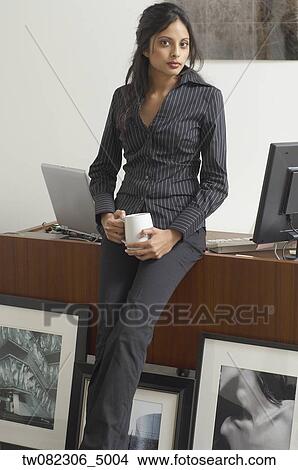 Picture - Middle Eastern businesswoman next to framed photography. Fotosearch