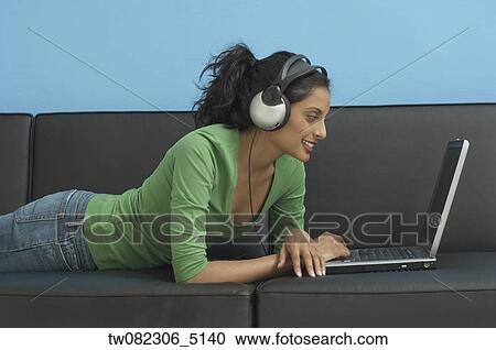 Middle Eastern woman looking at laptop and wearing headphones View Large Photo Image Stock Image - Middle Eastern woman looking at laptop and wearing headphones. Fotosearch