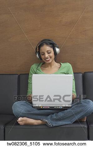 Middle Eastern woman typing on laptop and wearing headphones View Large Photo Image Stock Photography - Middle Eastern woman typing on laptop and wearing headphones. Fotosearch