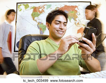 Pacific Islander businessman using electronic organizer View Large Photo Image Stock Photo - Pacific Islander businessman using electronic organizer. Fotosearch