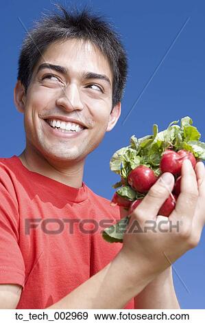 Pacific Islander man holding bunch of radishes View Large Photo Image Stock Photo - Pacific Islander man holding bunch of radishes. Fotosearch