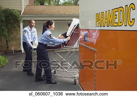 Stock Photograph - Paramedics putting woman into ambulance. Fotosearch