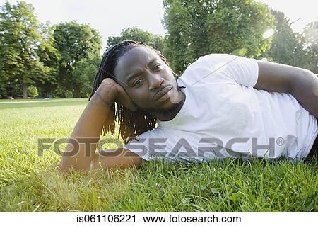 Portrait of African man laying in grass View Large Photo Image Stock Image - Portrait of African man laying in grass . Fotosearch