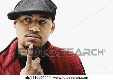 Stock Image - Portrait of African man with index finger on chin. Fotosearch