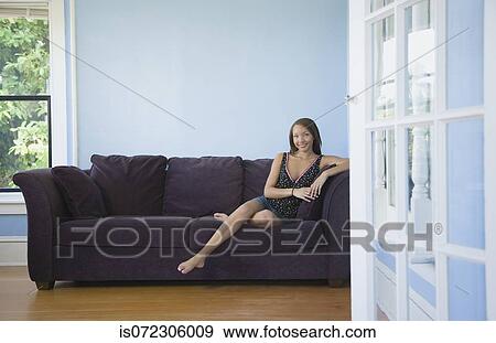 Stock Photo - Portrait of African woman on sofa. Fotosearch