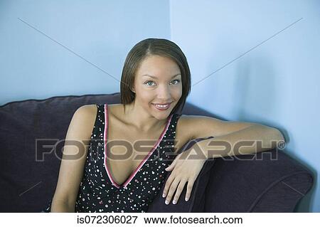 Stock Photo - Portrait of African woman on sofa. Fotosearch
