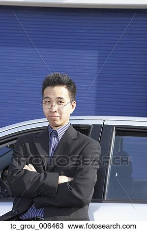 Portrait of Asian businessman leaning against car View Large Photo Image Stock Image - Portrait of Asian businessman leaning against car. Fotosearch