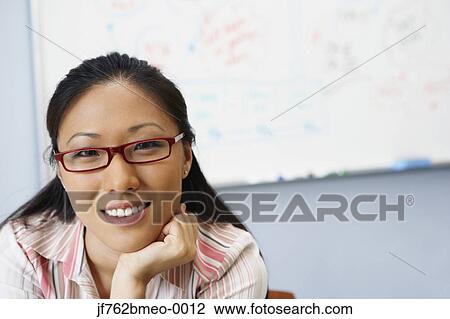 Stock Image - Portrait of Asian businesswoman in front of whiteboard. Fotosearch