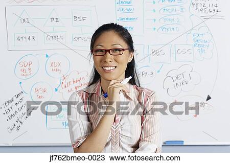 Stock Image - Portrait of Asian businesswoman in front of whiteboard. Fotosearch