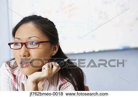 Stock Photo - Portrait of Asian businesswoman in front of whiteboard. Fotosearch