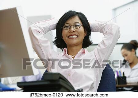 Portrait of Asian businesswoman with arms behind head View Large Photo Image Stock Image - Portrait of Asian businesswoman with arms behind head. Fotosearch