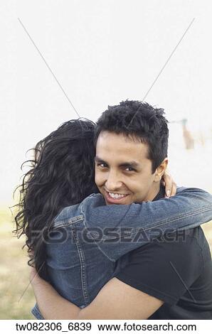 Stock Photo - Portrait of couple hugging outdoors. Fotosearch