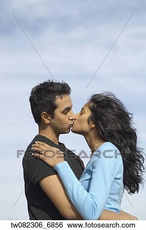 Stock Photograph - Portrait of couple kissing outdoors. Fotosearch