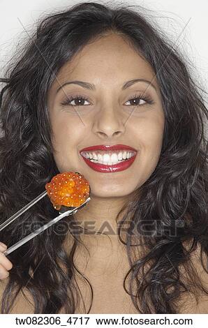 Portrait of Middle Eastern woman eating sushi View Large Photo Image Stock Photo - Portrait of Middle Eastern woman eating sushi. Fotosearch