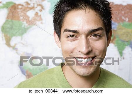 Stock Image - Portrait of Pacific Islander man in front of world map. Fotosearch