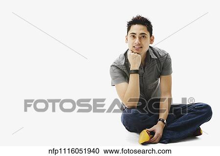 Stock Image - Portrait of Pacific Islander man sitting cross-legged. Fotosearch