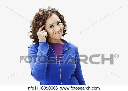 Stock Photograph - Portrait of woman pointing at temple. Fotosearch