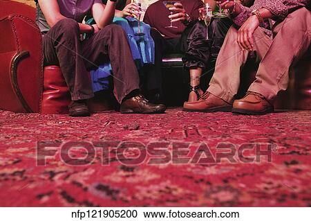 Stock Image - Surface shot of friends with cocktails. Fotosearch