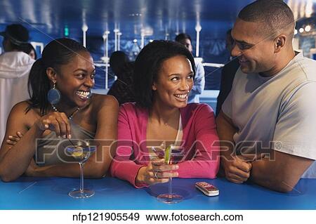 Three African friends laughing at bar View Large Photo Image Stock Photo - Three African friends laughing at bar. Fotosearch