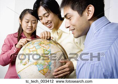 Three friends looking at globe View Large Photo Image Stock Image - Three friends looking at globe. Fotosearch