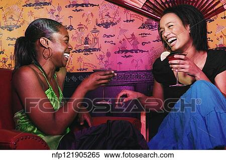 Two African women holding cocktails and laughing View Large Photo Image Stock Photography - Two African women holding cocktails and laughing. Fotosearch