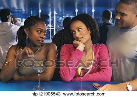 Two African women looking at each other at bar View Large Photo Image Stock Image - Two African women looking at each other at bar. Fotosearch