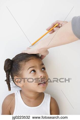 Adult measuring African girl's height View Large Photo Image Stock Image - Adult measuring African girl's height. Fotosearch