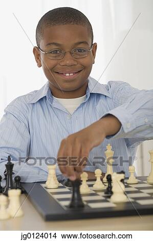 Picture - African boy playing chess. Fotosearch