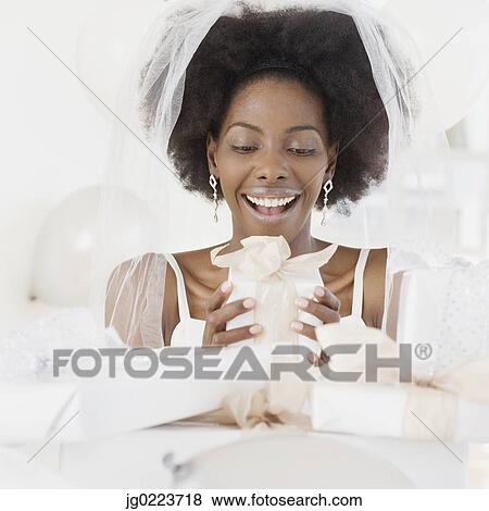 Stock Photo - African bride opening gifts. Fotosearch