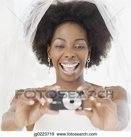 Stock Photo - African bride taking photograph. Fotosearch