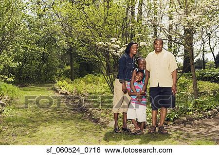 Stock Photograph - African family hugging in park. Fotosearch