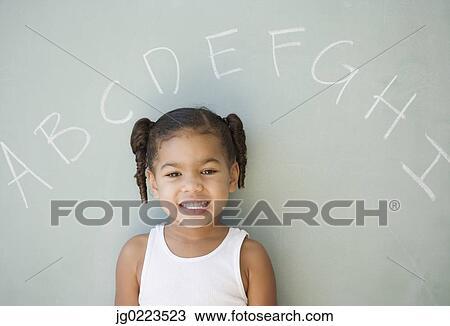 African girl leaning against blackboard View Large Photo Image Stock Image - African girl leaning against blackboard. Fotosearch
