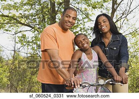 African girl on bicycle with parents in park View Large Photo Image Stock Image - African girl on bicycle with parents in park. Fotosearch