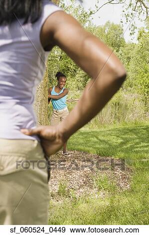 African girl standing next to tree looking at mother in foreground View Large Photo Image Stock Photo - African girl standing next to tree looking at mother in foreground. Fotosearch
