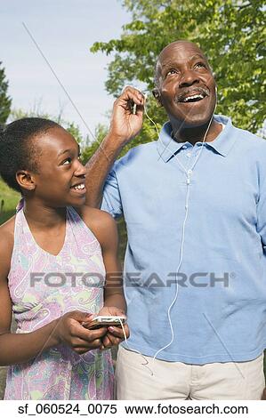 African grandfather listening to granddaughter’s mp3 player View Large Photo Image Stock Photography - African grandfather listening to granddaughter’s mp3 player. Fotosearch