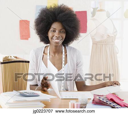 Stock Photo - African seamstress in design workshop. Fotosearch
