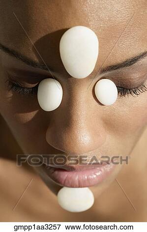 Stock Photo - African woman receiving spa stone treatment on face. Fotosearch