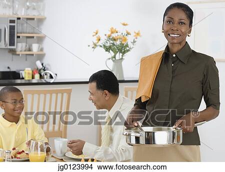 African woman serving breakfast to husband and son View Large Photo Image Picture - African woman serving breakfast to husband and son. Fotosearch