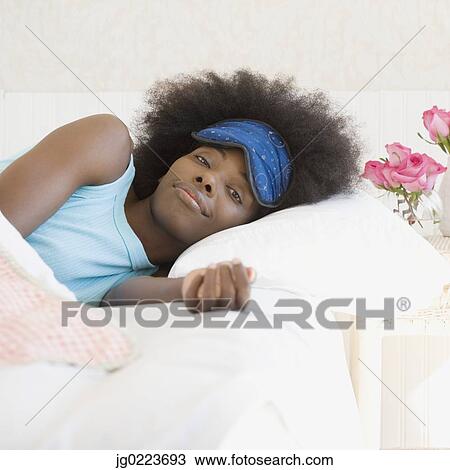 African woman wearing eye mask in bed View Large Photo Image Stock Image - African woman wearing eye mask in bed. Fotosearch